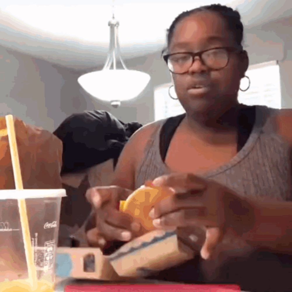 a woman sitting at a table with a coca cola cup