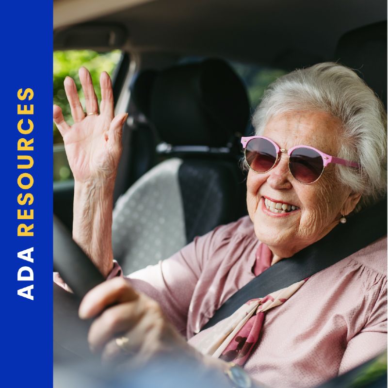 Elderly woman smiling with white hair and pink sunglasses driving a car, wearing a seatbelt and waving. The left side of the image features a vertical blue bar with the yellow text “ADA RESOURCES.”