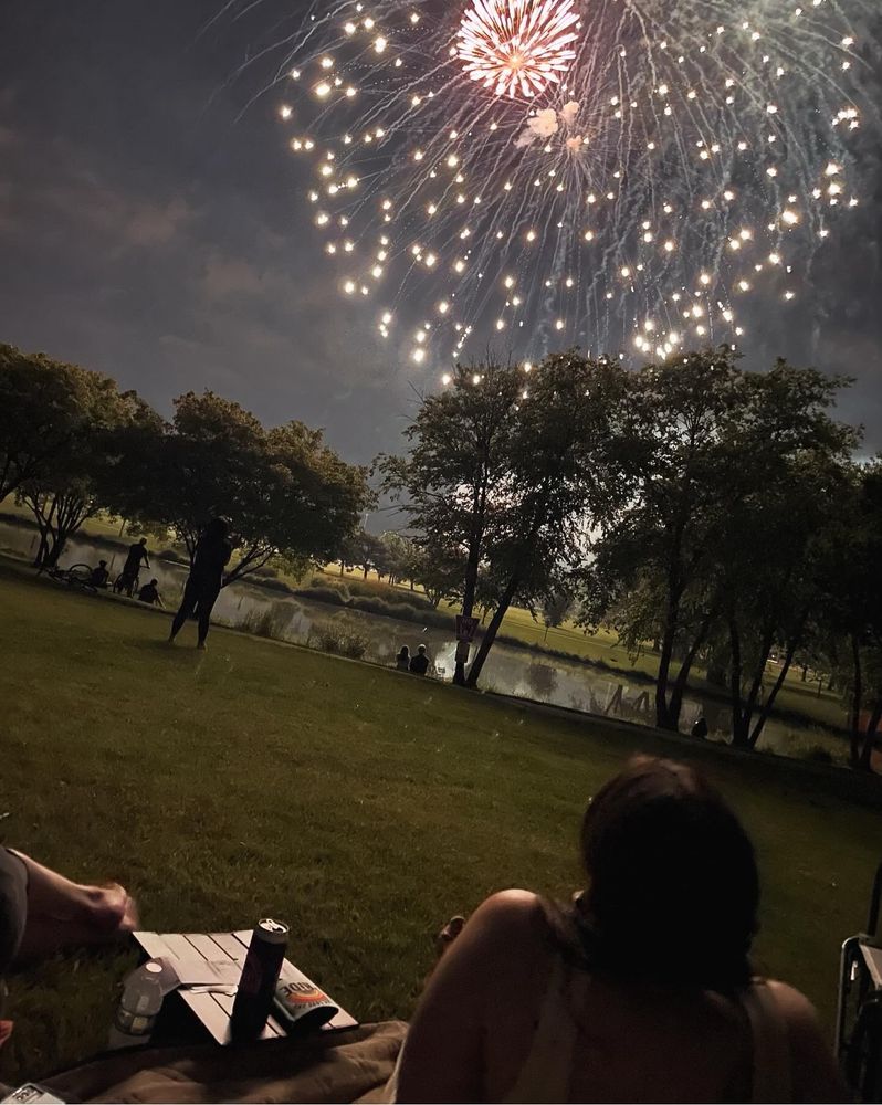 A photo of a fireworks in the night sky over a lake