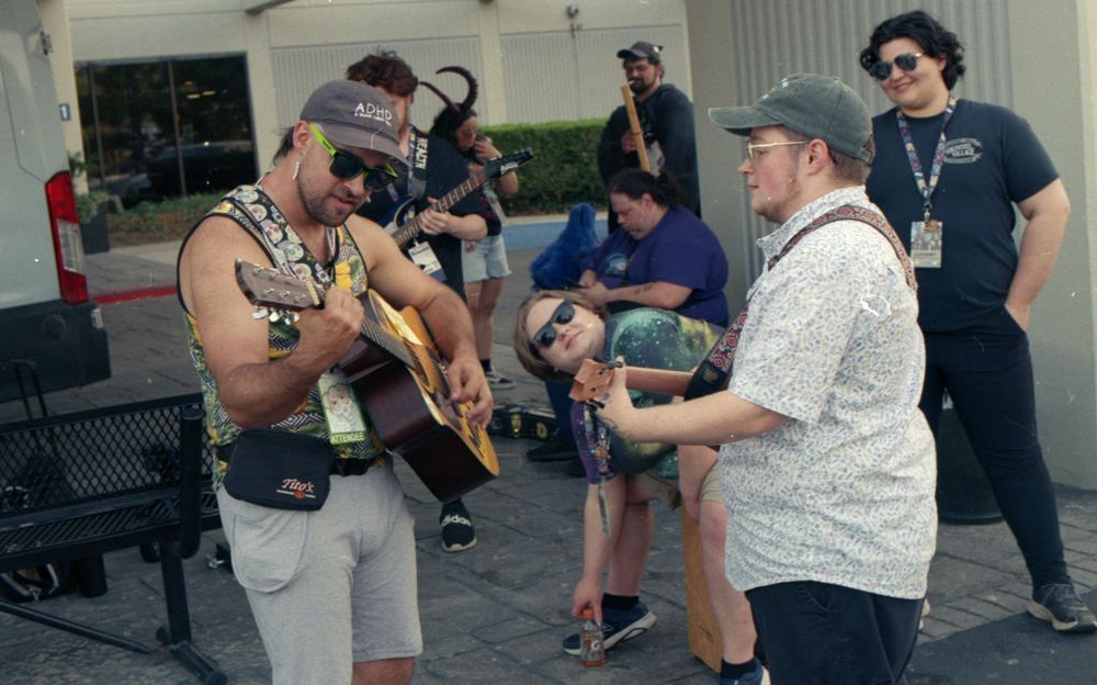 Two people playing guitars outside
