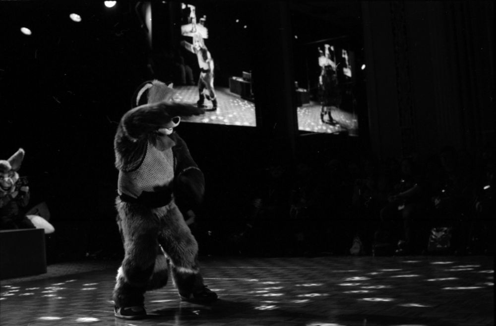 Black and white photo of Scooter dancing, one arm in front of face