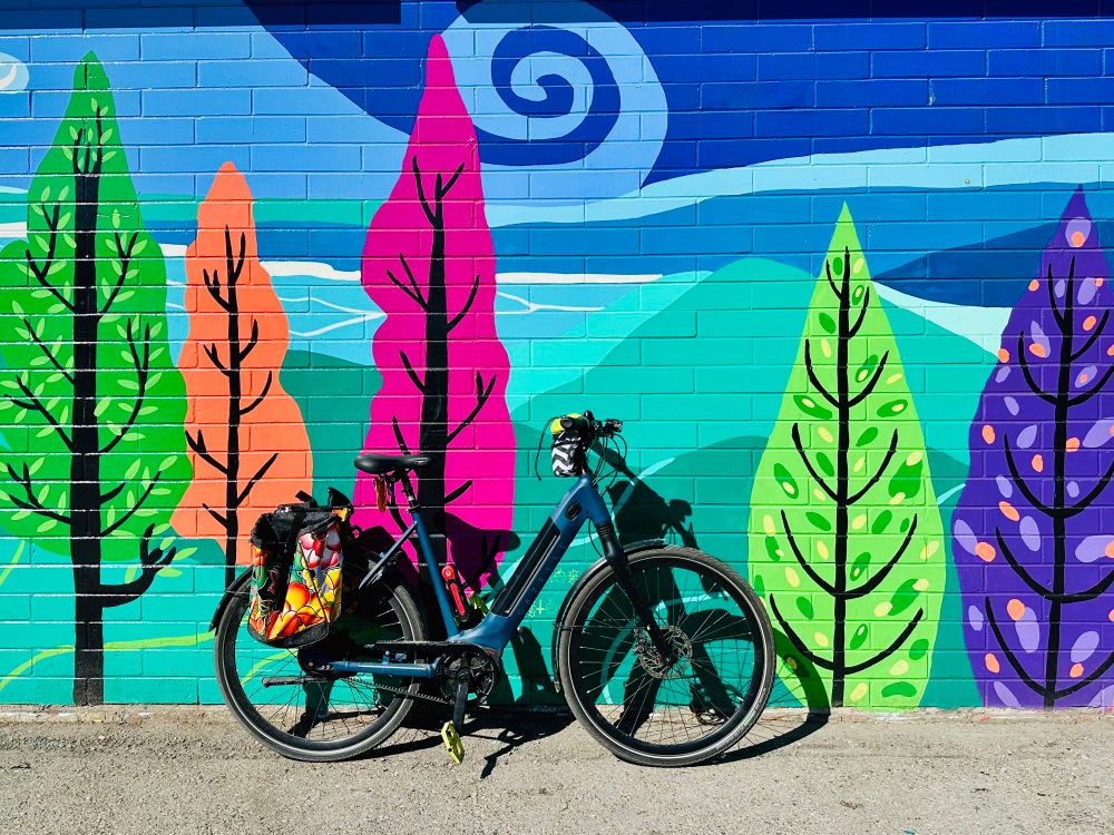 My bike against a mural of brightly coloured trees. 