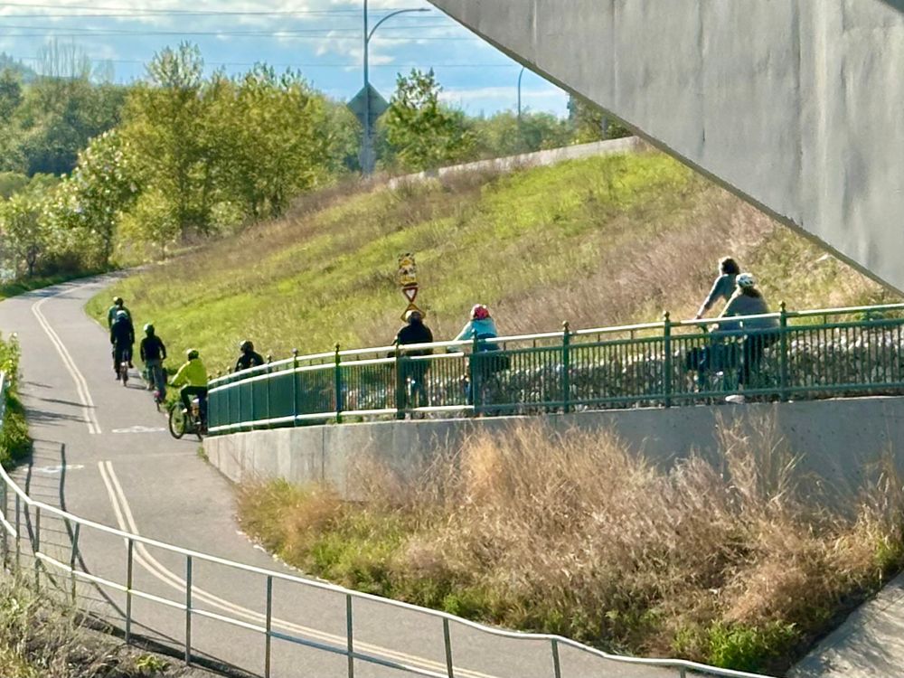 Bicycles riding down a hill from a distance. 
