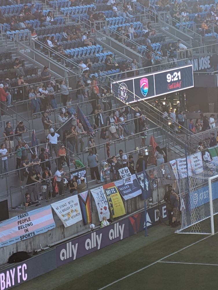Banners in front of the supporter's section include 