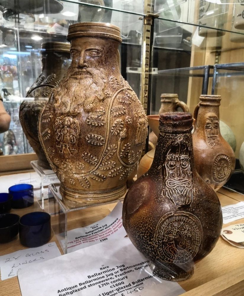 Photo of three Bellarmine jars with humanoid features and carved/moulded leaf decoration