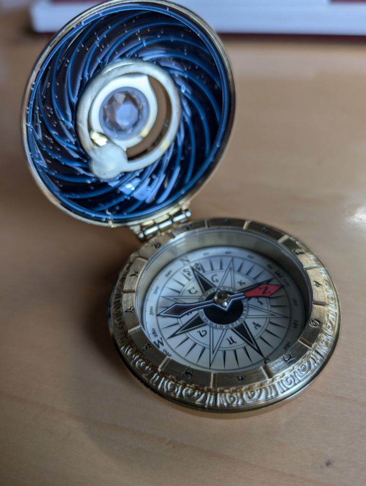 Interior of the way finder. Opened like a locket with a compass surrounded by runes. Inside ceiling is a blue swirl pattern 