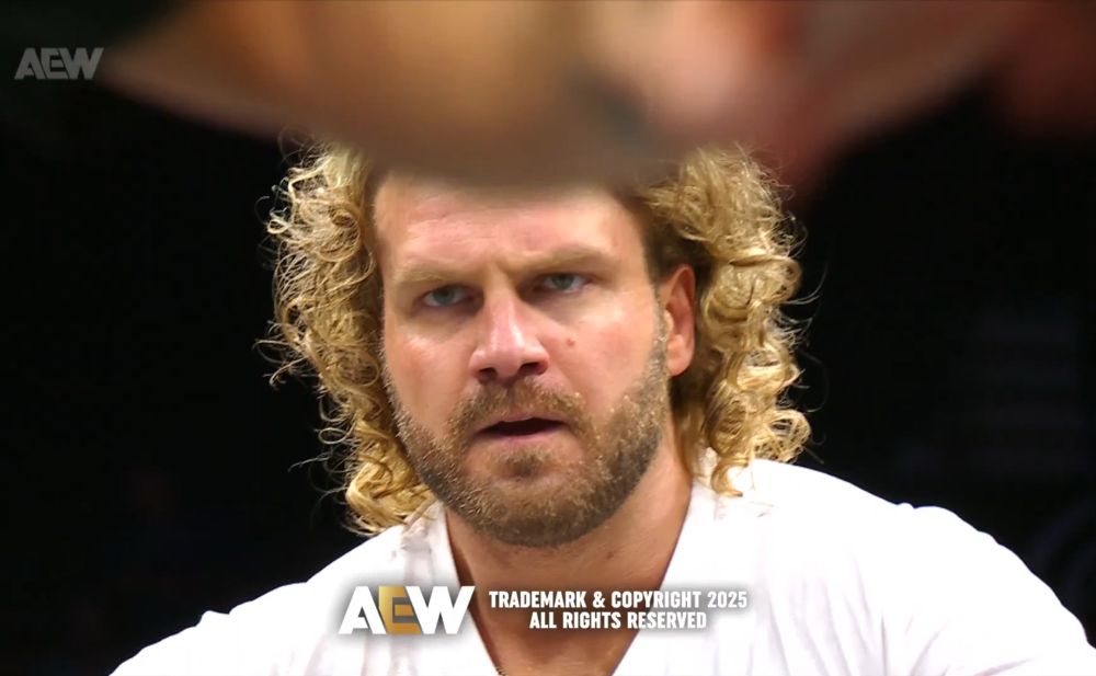 close up of hangman’s face looking focused and honestly annoyed at mjf yelling at him off of the ramp 