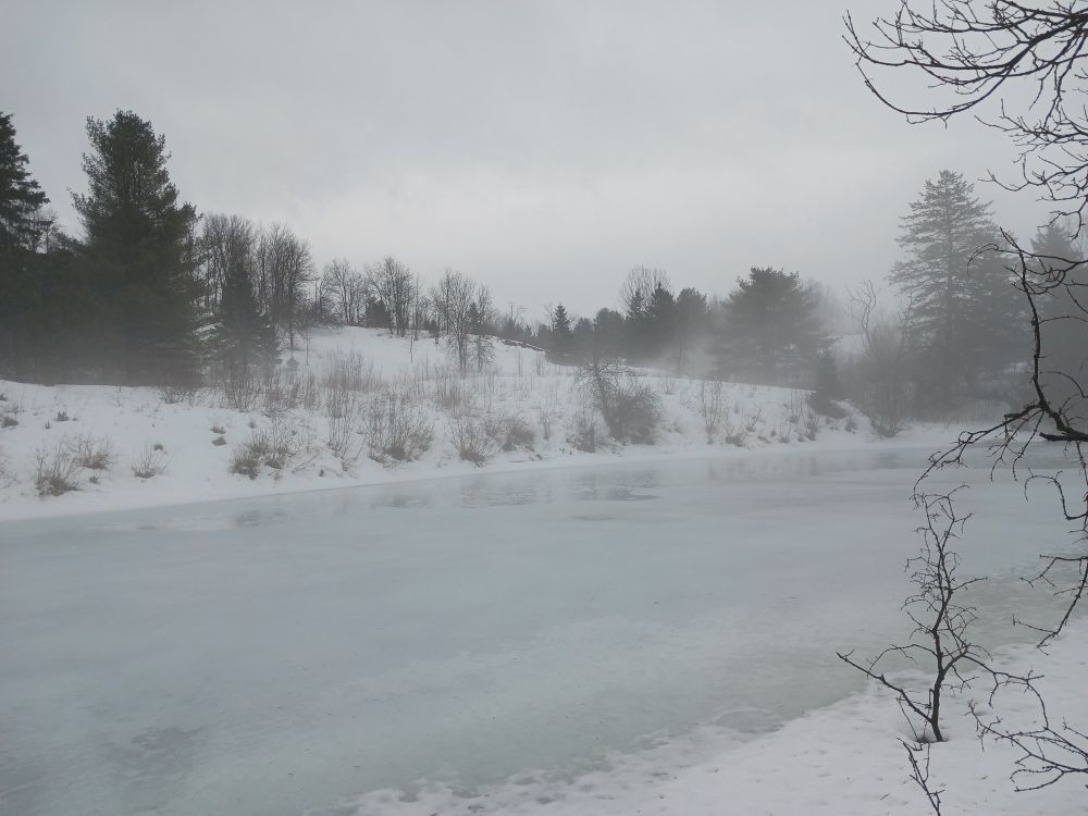 picture of a winter river with fog and ice