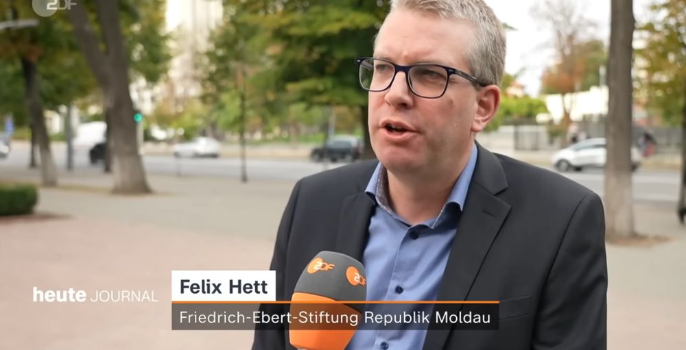 Ein Mann, Felix Hett von der Friedrich-Ebert-Stiftung Moldau, spricht auf einem Bürgersteig ins Mikro des ZDF.