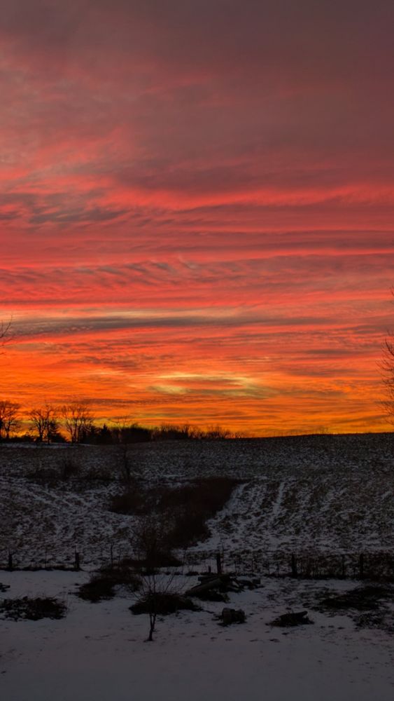 A multi-colored sky at Sunset over a snow covered landscape.
