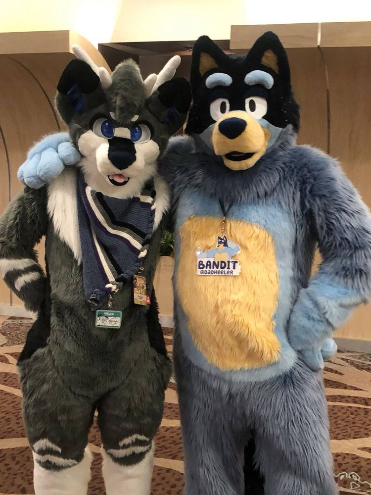 Jenga and Bandit standing side by side in fursuit.