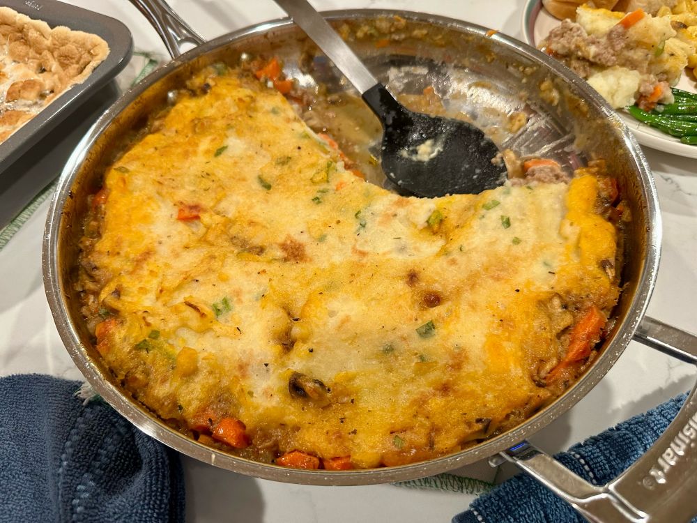 Pan of vegetarian shepherds pie with a few scoops taken out.