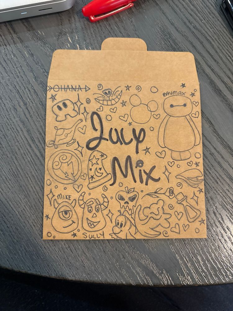 Photo of a cd sleeve covered in Disney doodles like Baymax from Big Hero 6 and Mike and Sully from Monsters Inc.