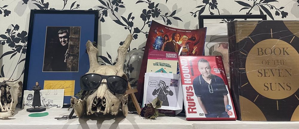 Collection of merch of the meddling monk and actors who’s played them. Including a signed picture of Peter butterworth. A butterworth monk figure. A magazine cover featuring Tamzin Drew. A recreation of the meddling nuns book TARDIS, and a copy of the Rufus Hound stand up DVD. 