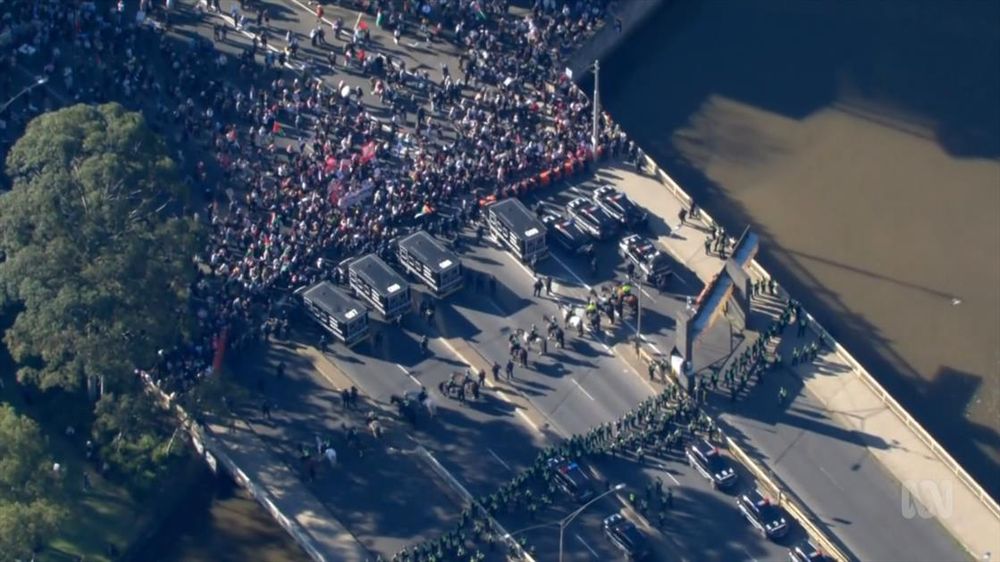 Image from ABC TV News Melbourne showing King Street Bridge with protestors, and police blocking their way onto the bridge.