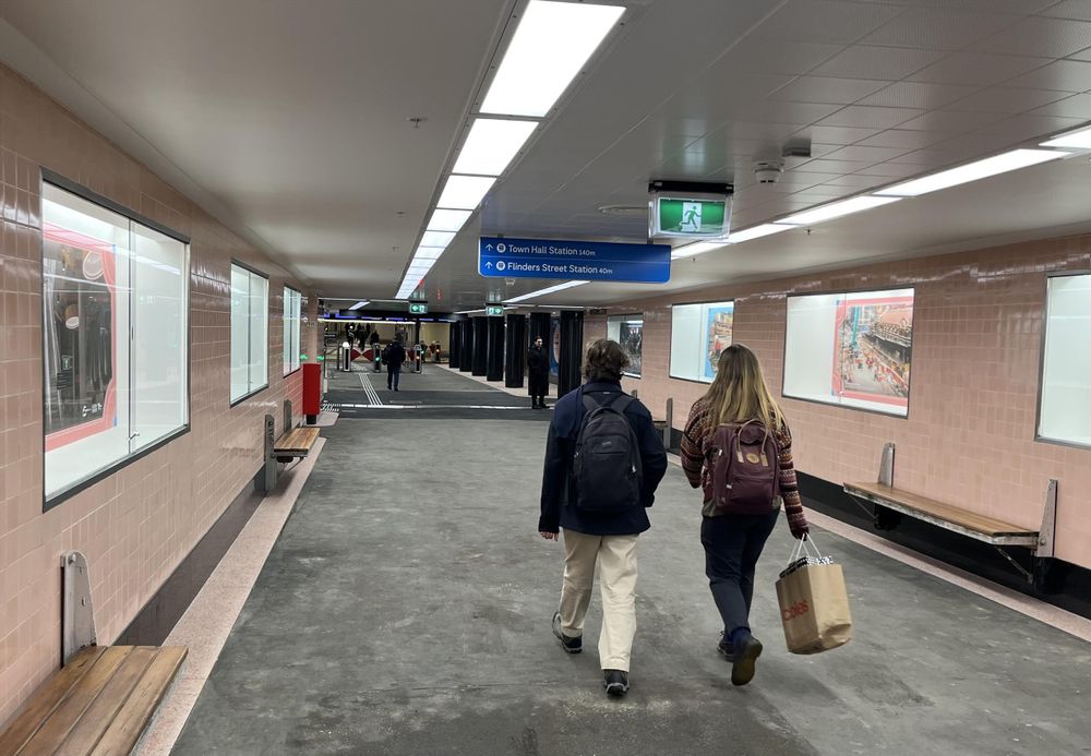 People walking along the subway towards the entrance to Flinders St station