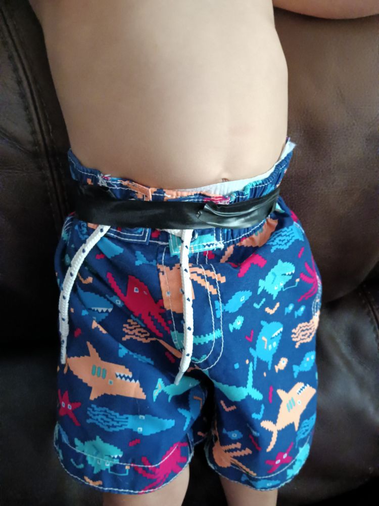 Photo of my toddler grandson with electric tape holding his oversized swim trunks up.

PopPop's method of making swim trunks fit. Protects from low hanging, dangling high voltage lines as well.