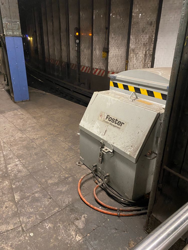 A box for a curve greaser mechanism on the subway, with the branding "Foster Friction Management" on it 