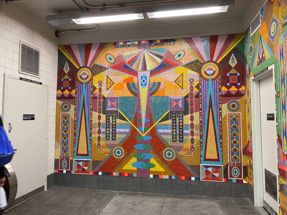 Vibrant colored tiles decorate the wall of a subway entrance 
