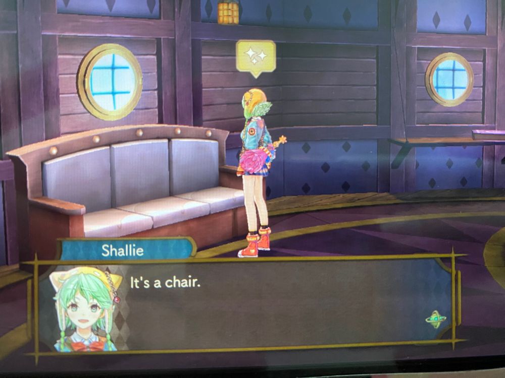 Shallie says "it's a chair" while standing in front of what is obviously a couch