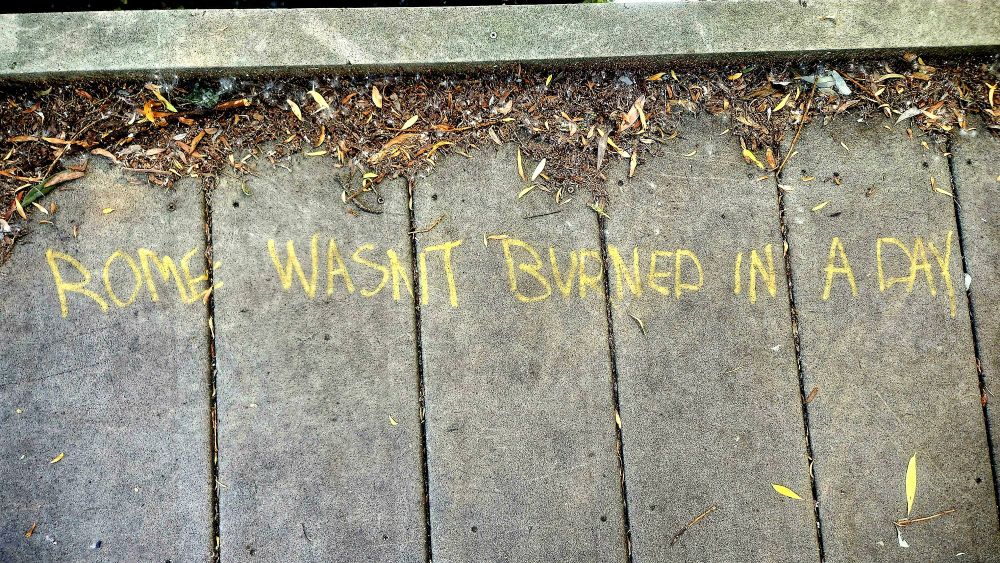 "Rome wasn't burned in a day" graffiti on a bridge