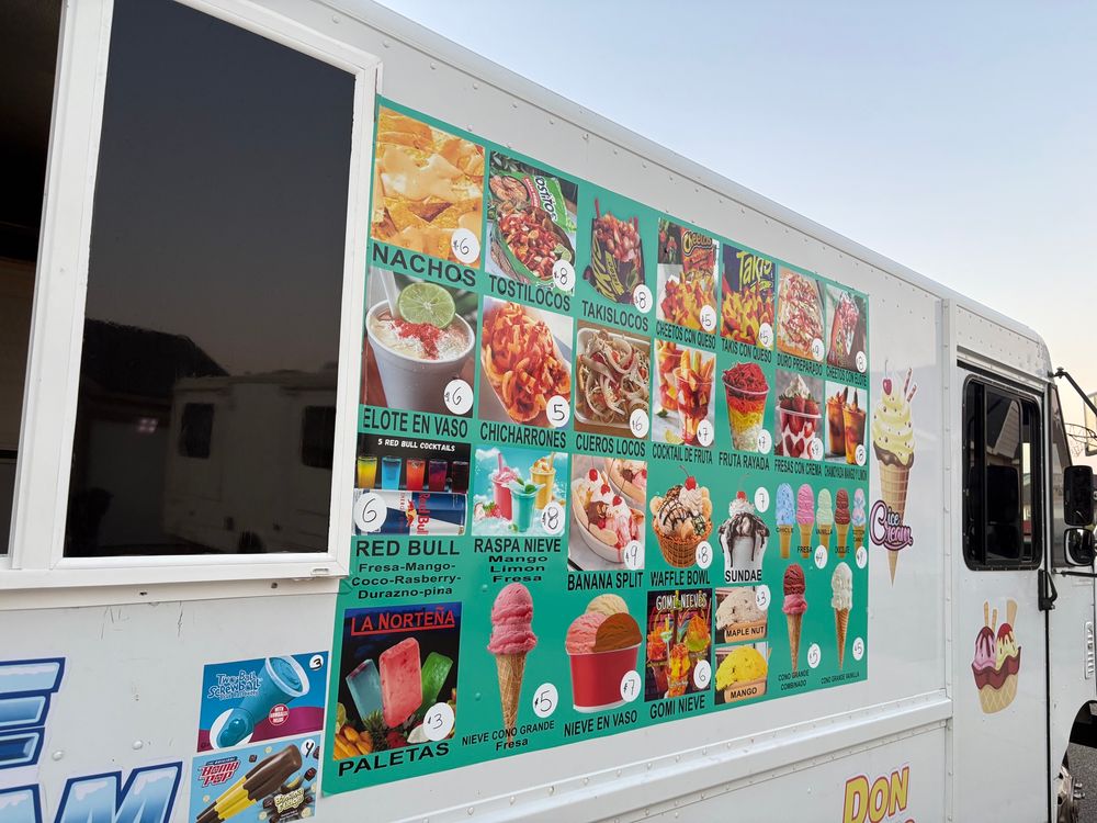 Photo of a large menu on the side of a truck. The menu includes items such as ice cream, nachos, chicharrones, and takis con queso.