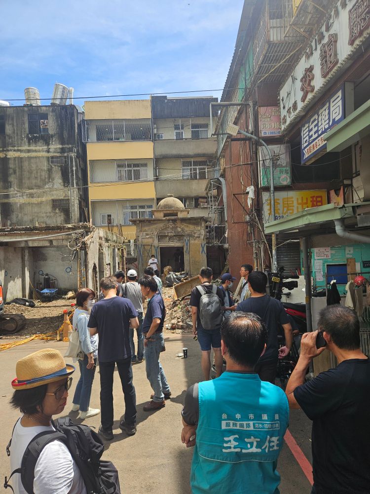 A crowd of onlookers in the alleyway leading to a mysterious building in Taichung.