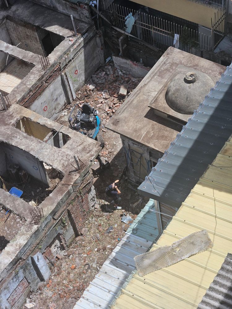 The newly rediscovered structure from the nearby rooftops. A lone photographer is capturing the scene down below.