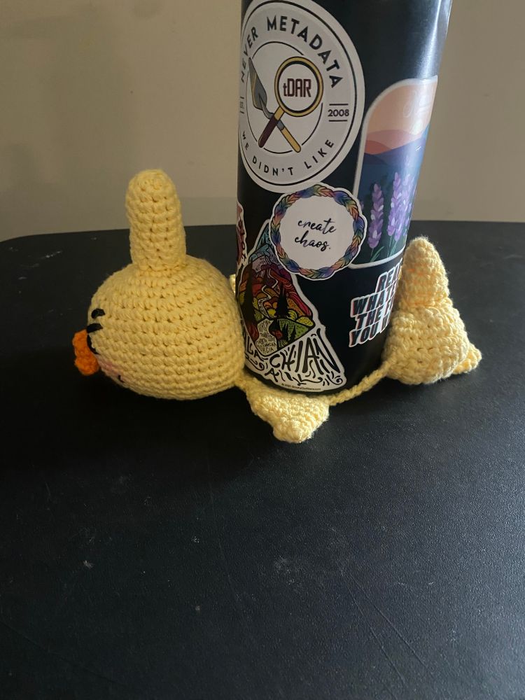 A picture of my bbyongming coaster from the side, showing that he’s constructed to look like whatever you set on top is crushing him 