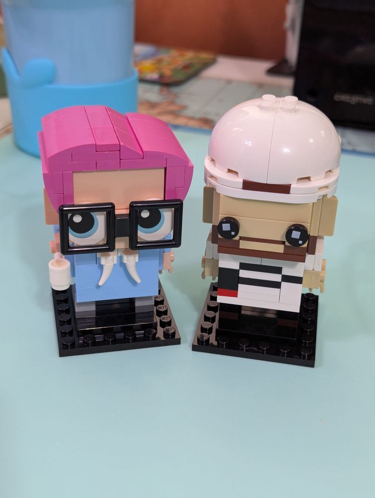 Brickheads one with pink hair blue hoodie one with white shirt with a P and backwards baseball cap