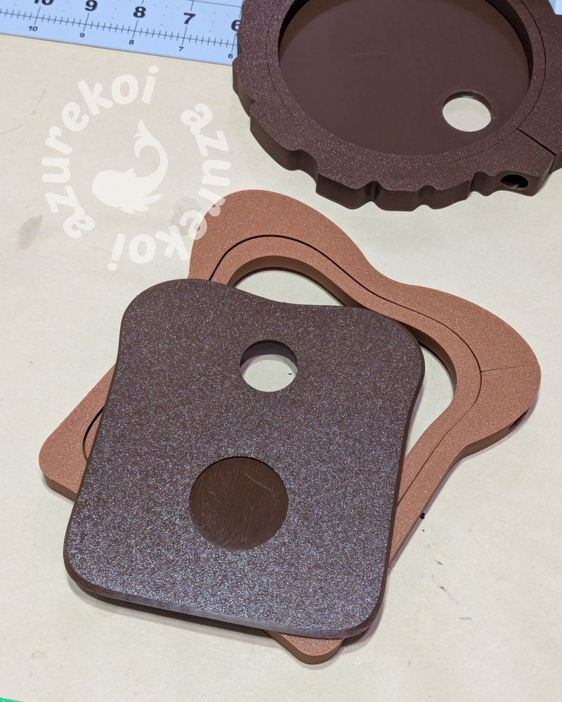 Back panel of the toast embroidery hoop in dark brown lying on top of the hoops which is a medium brown