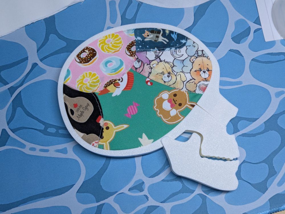 skull shaped embroidery hoop with various fabrics inside
