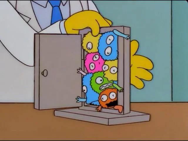 Image of doctor in a lab coat shoving several germ-shaped toys through a small model of an open door; they are all stuffed on top of each other, making it too tight for any of them to make it through. 