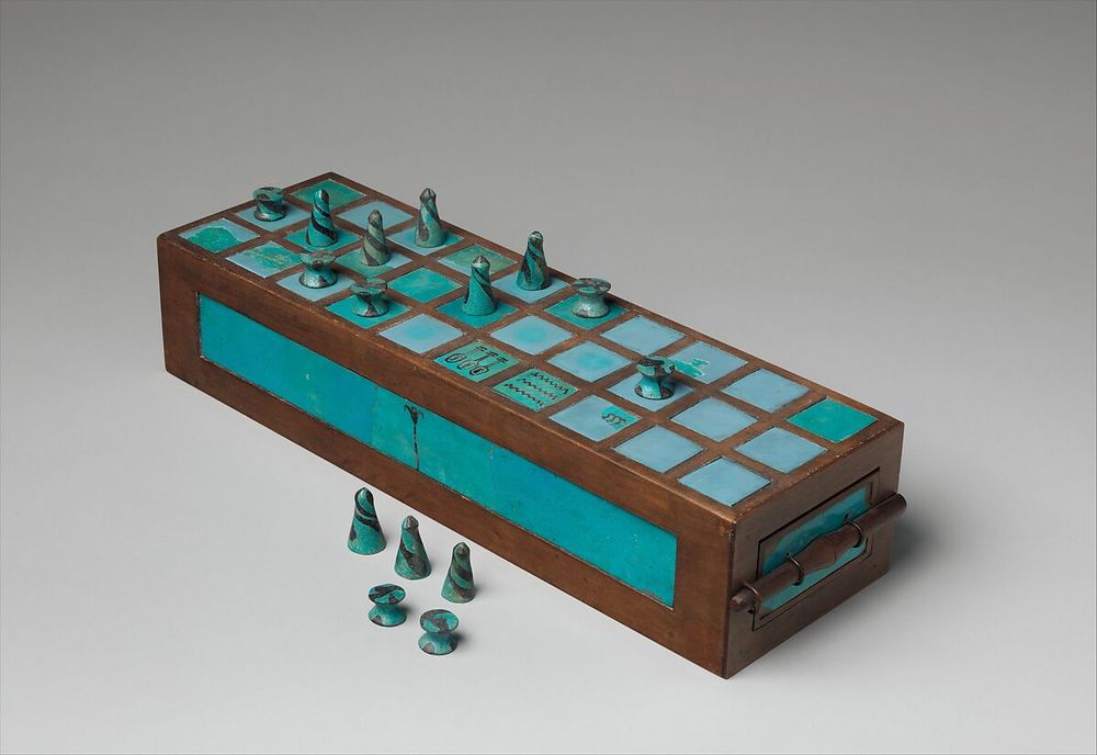 A 3/8 view of a blue faience inlaid brown wooden Senet board game box on a clean white background from the NYC Met: https://www.metmuseum.org/art/collection/search/544775