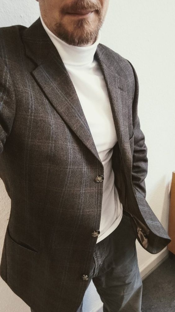 Outfit-Büro-Selfie mit braun-grauer Feincordhose, dünnem cremefarbenem Rollkragenshirt und braun gemustertem Sakko (Streifen und Fischgratmuster)
