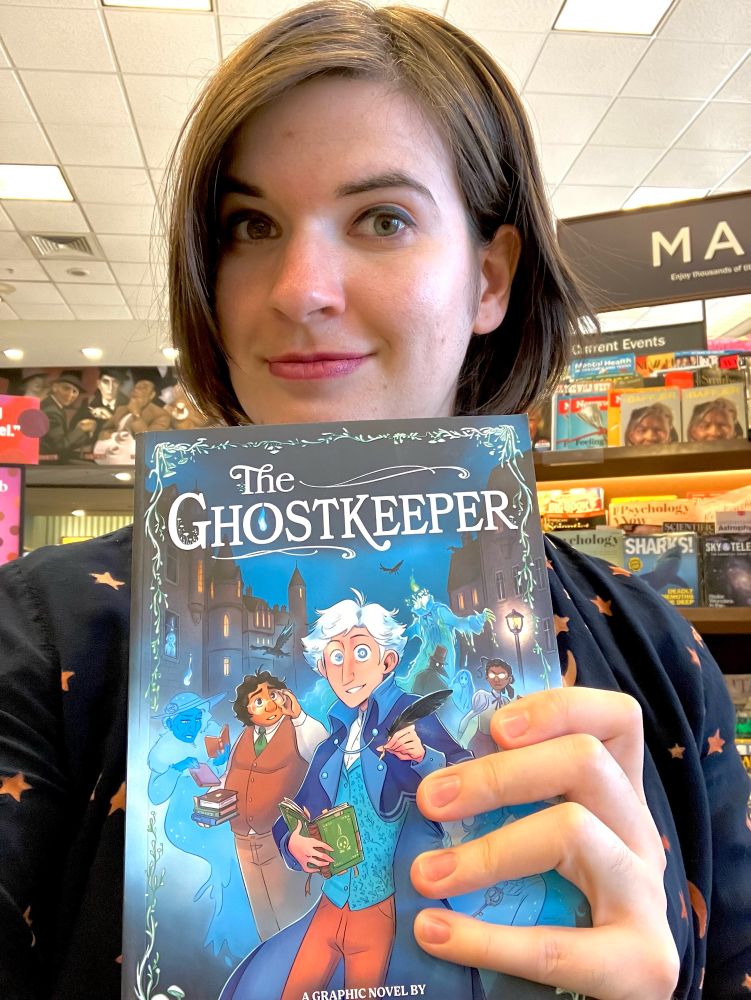 Me holding a copy of the ghostkeeper 