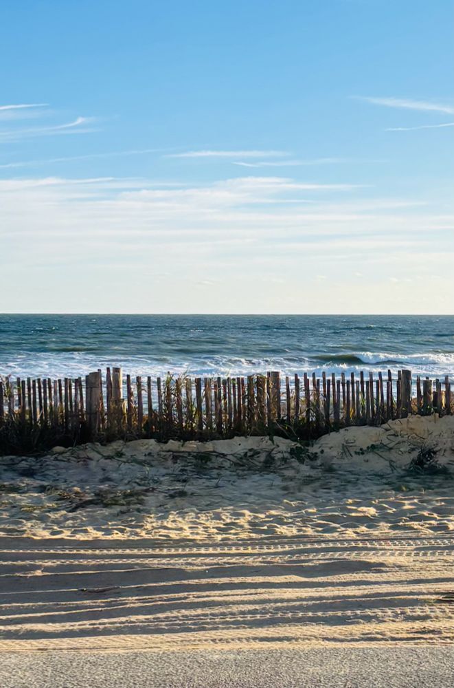 Bluesky, blue wave ocean, dunes with a fence, more sand 