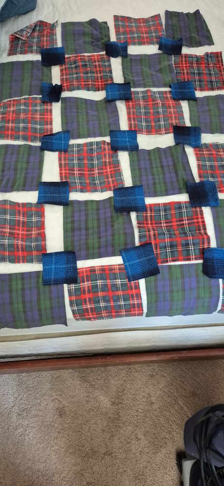 Flannel quilt squares laid out in a pattern, waiting to be sewn together