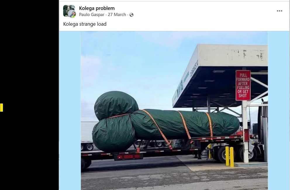 Facebook post from 27 March 2007 shared by a Polish meme group called Kolega (Mate) Problems with the text "Kolega strange load"
image: large phallic object wrapped in a green tarp and secured with straps on the back of a flatbed truck at what appears to be a gas station. The object's shape has led to humorous and suggestive comments on social media platforms since March 2025. The exact nature of the object is not specified. 
A sign reads: "PULL FORWARD AFTER FUELING OR GET SHOT" which suggests American gas station humour.