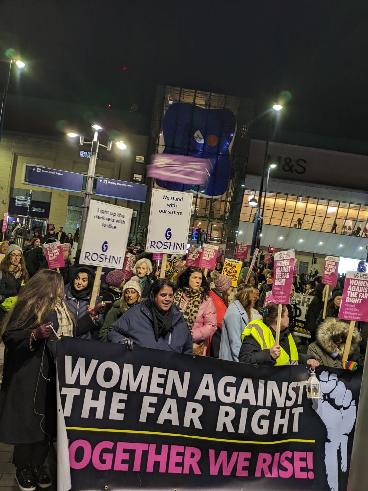 Women Against the Far Right holding their banner "Together We Rise*