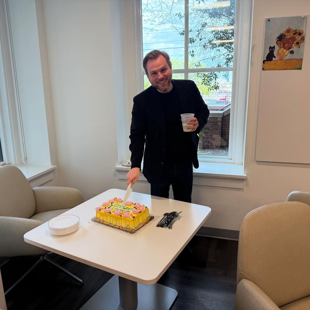 Stephen Taylor cutting a cake to celebrate his academic tenure.