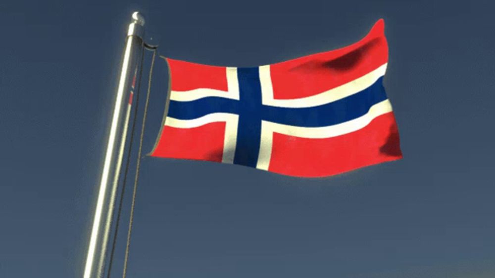 a norwegian flag is waving in the wind against a blue sky