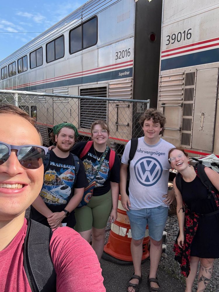 Brian is taking a selfie with four friends in front of the Amtrak Empire builder at St. Cloud Station