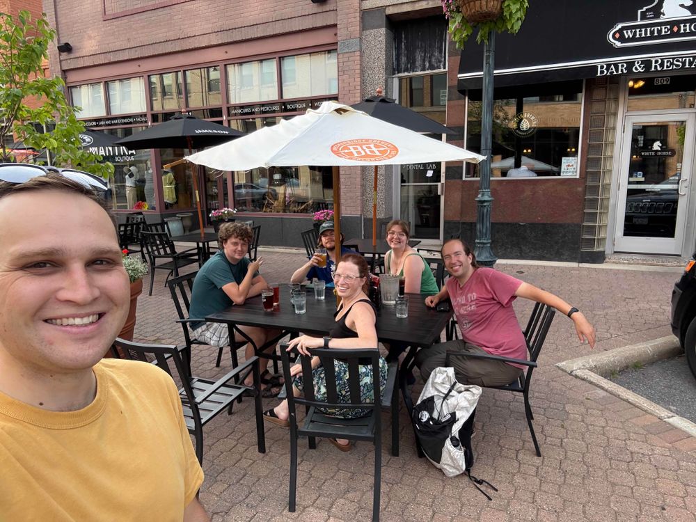 Brian is taking a selfie with five friends sitting at a table at White Horse restaurant in St. Cloud