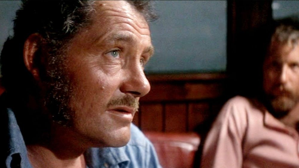 Quint from Jaws with a haunted look, a concerned Richard Dryfuss looking on