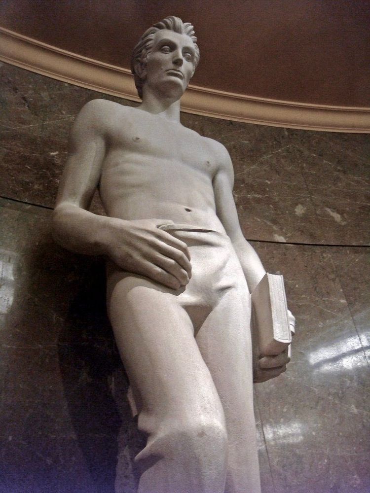 Statue of Babe Lincoln, with a twilight physique, shirtless, leaning against the wall with one leg up. He's holding a book on one hand and has his other hand hanging off his pants by his thumb, pulling the fabric down a little, teasing at his fun little play area before you get to the utilities and equipment. If Calvin Kline or Abercrombie or whatever did statues in their stores, they'd look like this.