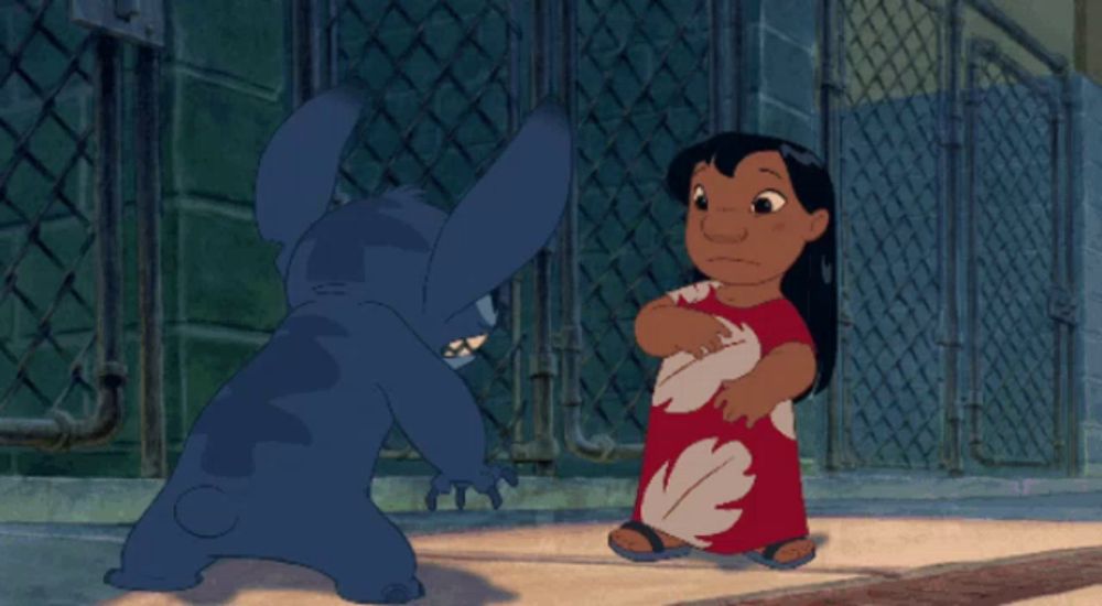 stitch and a girl are standing next to each other in front of a chain link fence