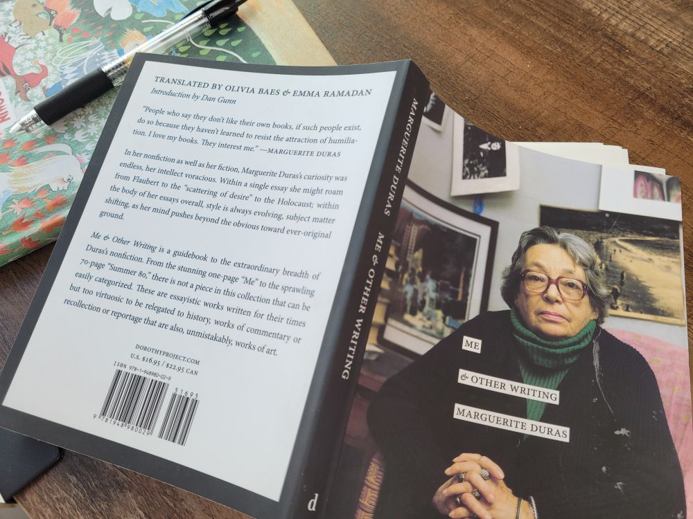 The book ME & OTHER WRITINGS by Marguerite Duras lies open on a table.