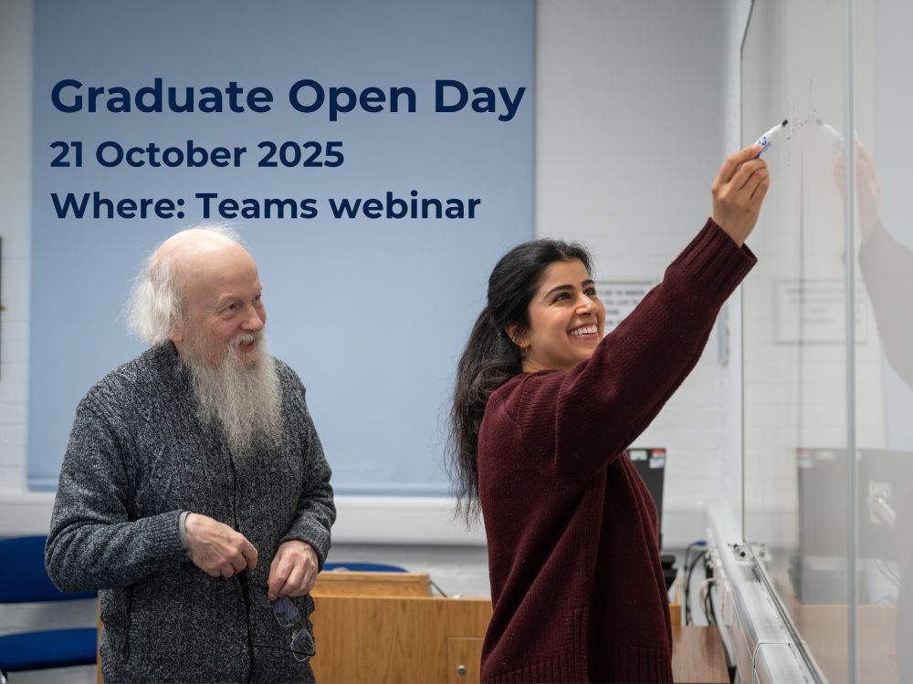 A photograph of two people, one older man with a white beard, and a younger woman with dark black hair. They are both smiling and looking at a whiteboard that the young woman is writing on. There is text written over the top left of the image reading ‘Graduate Open Day. 21 October 2025. Where: Teams webinar’.
