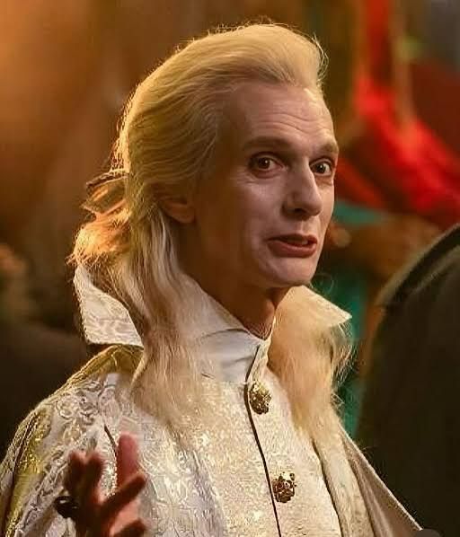 Actor Doug Jones, not a politician, making a goofy face as Baron Afanas on What We Do in the Shadows. He has long blond hair and is dressed in some gold vampire bullshit that would put Donald Trump to shame.